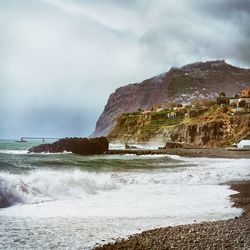 Scenic view of beach by sea against sky