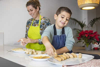 Mother and son making croquettes in the kitchen