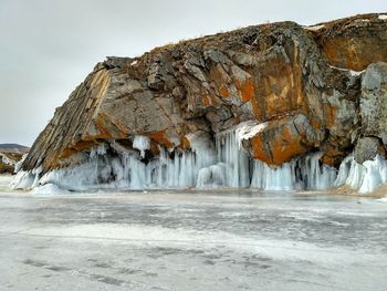 Icicles on snow covered mountain against sky