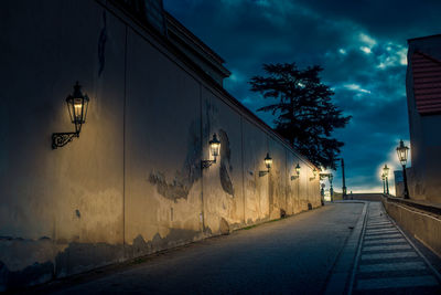 Street by road against sky at dusk