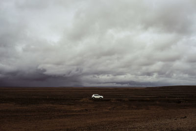 Scenic view of agricultural field against cloudy sky