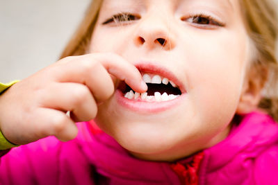 Close-up portrait of girl touching teeth