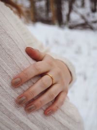 Close-up of woman hand on snow