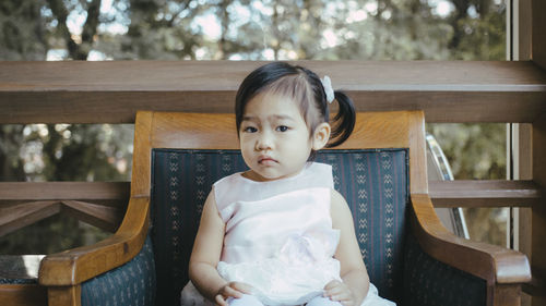 Portrait of baby girl sitting on armchair