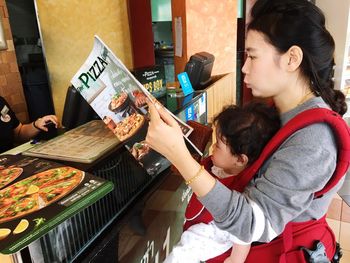 Side view of woman with son reading menu