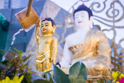 Close-up of buddha statue against temple