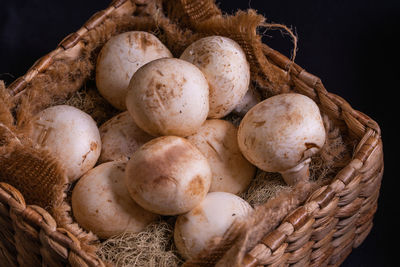 Close-up of mushrooms in basket on wooden table