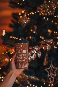 Female hands holding a cup of coffee or tea with a christmas design. winter holiday decor, new year 