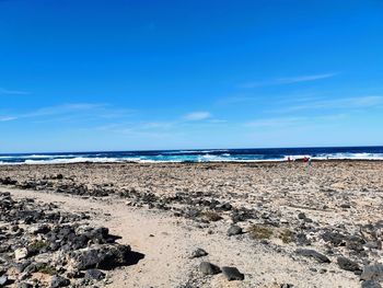 Scenic view of beach against blue sky