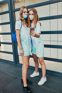 Full length of a woman standing against building