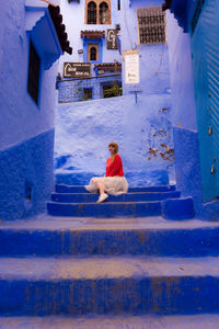 Man sitting on staircase outside building