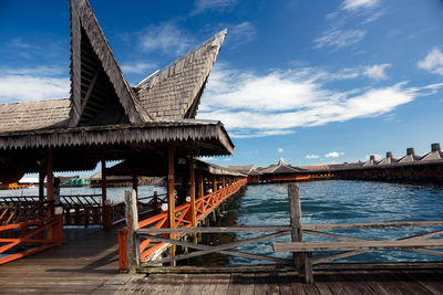 Gazebo by river against sky