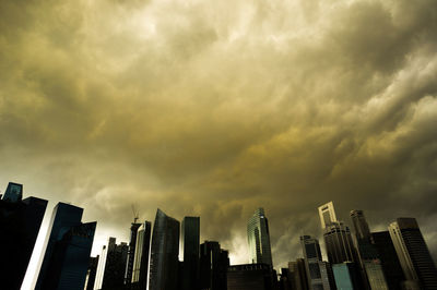 Low angle view of modern buildings against cloudy sky
