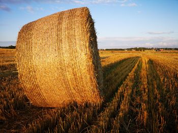 Hay bales on field against sky