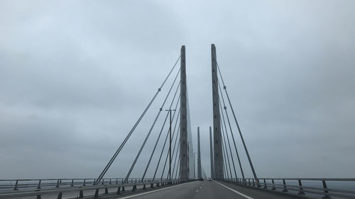 Low angle view of suspension bridge against sky