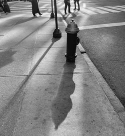 Low section of people walking on street in city