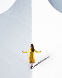 Young woman standing on yellow umbrella