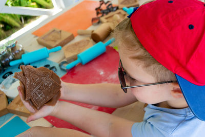 Bakers hand spraying egg-white on gingerbreads