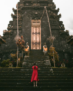 Rear view of woman standing outside temple