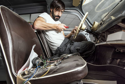 Portrait of man repairing car in factory