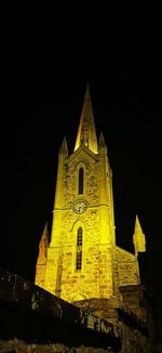 Low angle view of illuminated building against sky at night