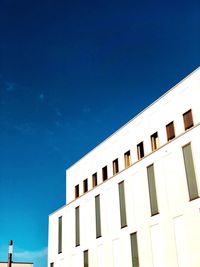 Low angle view of modern building against blue sky