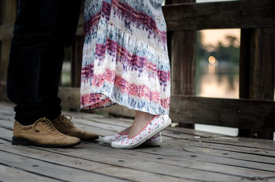 Low angle view of couple standing on wooden pier