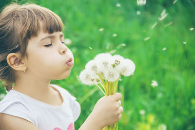 Close-up of girl blowing dandelion