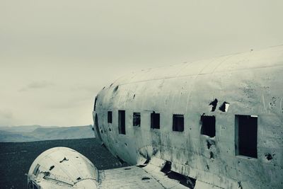 Abandoned airplane on field against sky