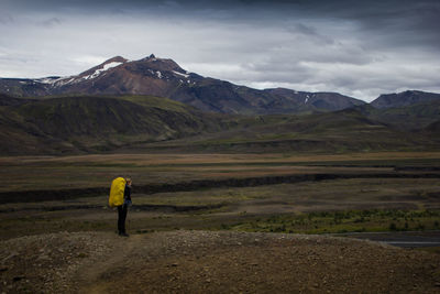 Woman standing on mountain against sky