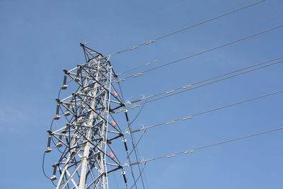 Low angle view of electricity pylon against clear sky