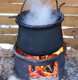 Black pot with the fire lit and the dense white smoke