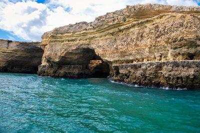 Rock formation in sea against sky