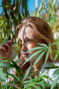 Beautiful woman amidst marijuana plants