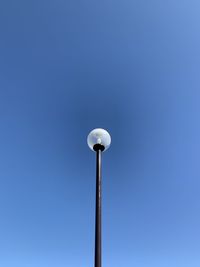 Low angle view of street light against blue sky