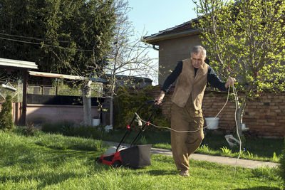 Full length of man mowing at yard