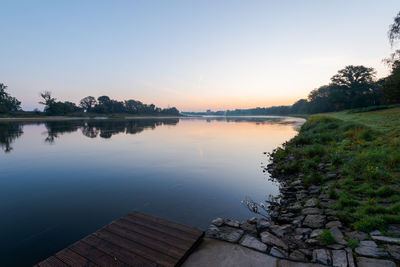 Scenic view of lake against sky at sunset
