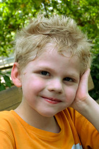 Close-up portrait of smiling boy sitting outdoors