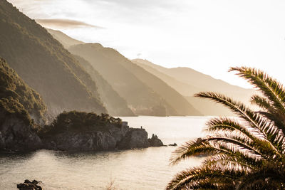 Scenic view of sea and mountains against sky