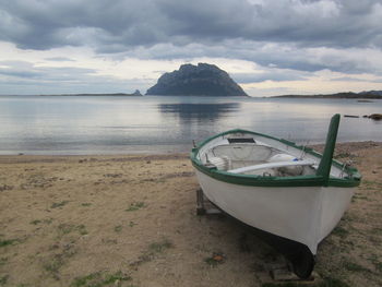 Boat moored on beach against sky