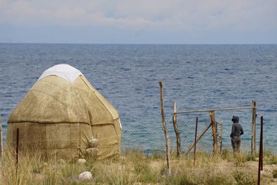 Rear view of people on beach against sky