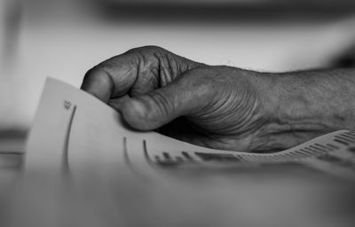 Close-up of hand holding paper with text