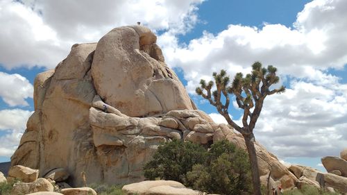 Low angle view of rock formation against cloudy sky