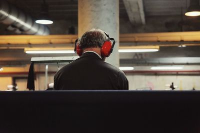 Rear view of man listening to music in textile factory