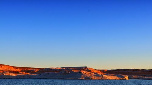 Scenic view of desert against clear blue sky