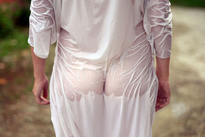Rear view of man with wet clothes standing outdoors