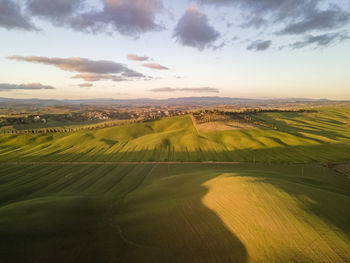 Scenic view of agricultural field against sky during sunset