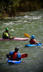 Rear view of people enjoying in river