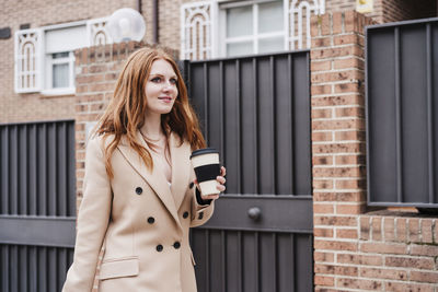Portrait of young woman standing on mobile phone