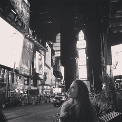 Woman standing on city at night